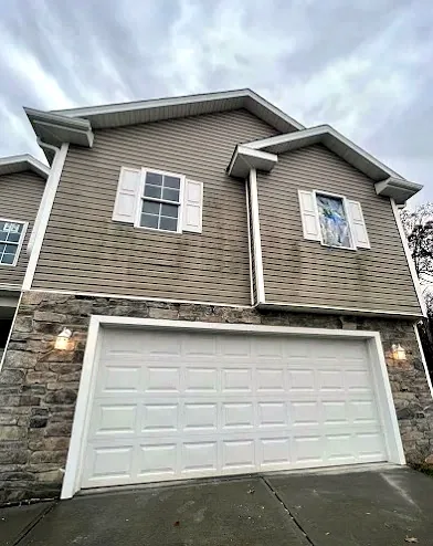 White double garage door set in a stone facade